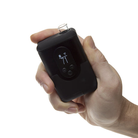 a hand holding an electronic device with a button on it